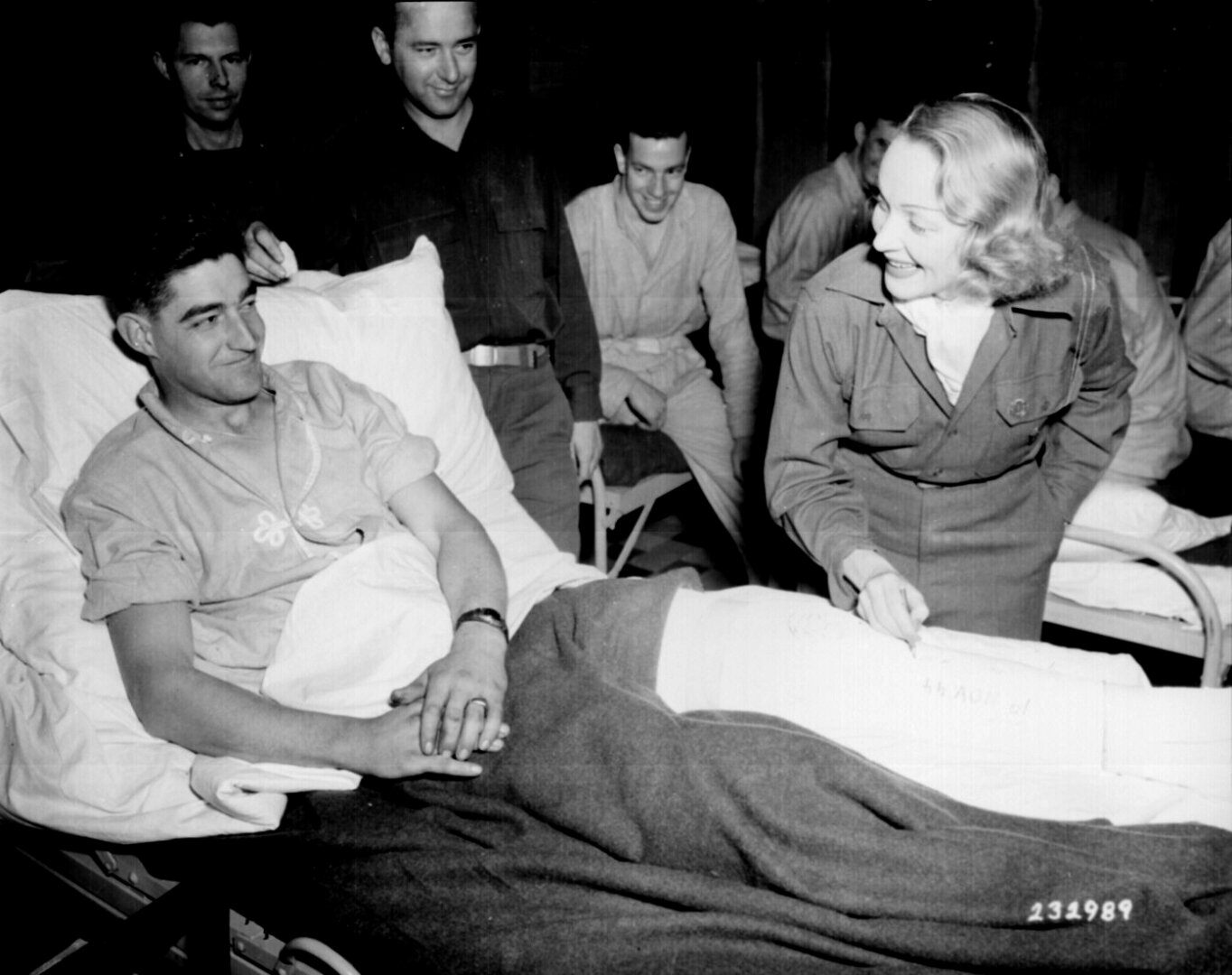 Marlene Dietrich a mozicsillag Earl E. McFarland sebesült katona begipszelt lábára írja nevét, az Egyesült Államok tábori kórháznál Belgiumban, 1944. november 24-én, fellépését követően - forrás: wikipedia/közkincs
